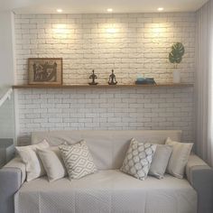 a living room with white brick walls and pillows