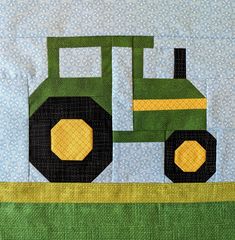 a quilted wall hanging with a green tractor on it's front and side