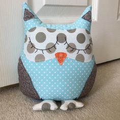 an owl pillow sitting on the floor next to a door