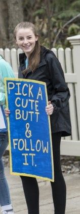 two girls holding a sign that says pick a cute but & follow it