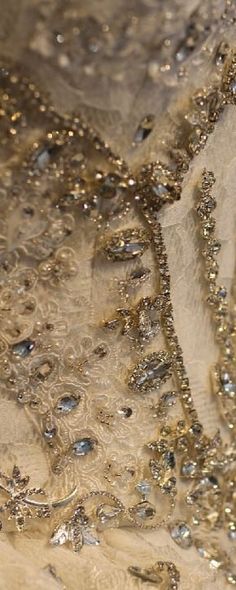 a close up view of a dress with gold sequins and beads on it