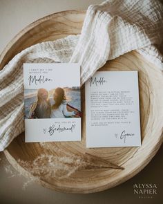 two wedding cards sitting on top of a wooden bowl