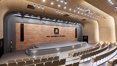 an empty auditorium with rows of seats and a podium on the stage that says city university of hong kong