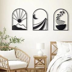 three black and white paintings on the wall above a bed