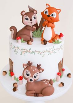 a white cake topped with animals and mushrooms