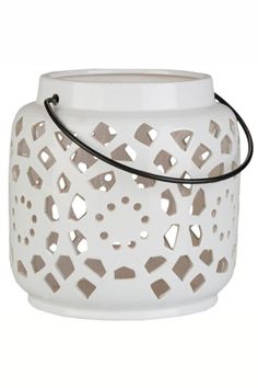 a white candle holder with cut out holes on the front and sides, hanging from a black cord