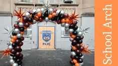 an arch made out of balloons and starbursts in front of a building