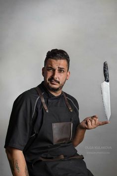 a man in an apron holding up a knife