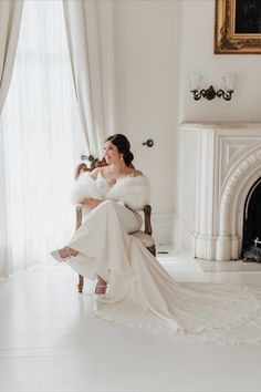 a woman in a wedding dress sitting on a chair