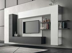 a modern living room with white and gray furniture, bookshelves and television on the wall