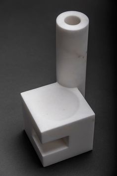 a white toilet sitting on top of a black floor next to a roll of toilet paper