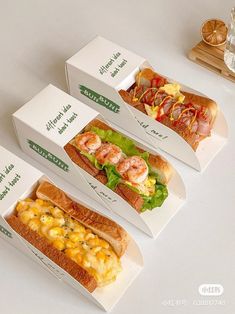 three boxes with different types of food in them sitting on a white counter top next to a glass of water