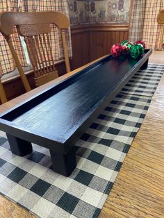 a long black table with two red and green balls on the top in front of it