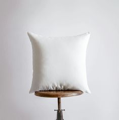 a white pillow sitting on top of a wooden table