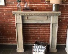 a brick fireplace in a living room next to a lamp