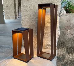 two modern outdoor lighting stands next to each other