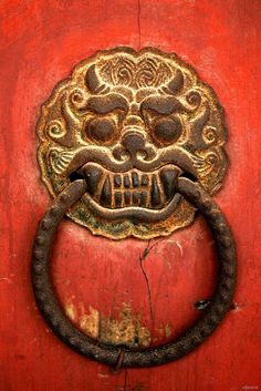 an old door handle with a skull head on it's face and a metal ring in the middle