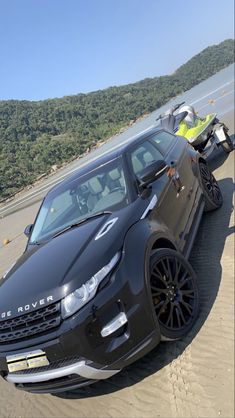 a range rover parked on the beach next to a motorcycle