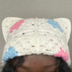 a close up of a person wearing a knitted hat with cat ears on it