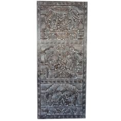 an intricately carved metal panel with animals and flowers on it, in grey tones