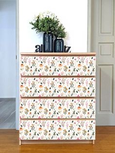 an image of a dresser with flowers on the top and bottom drawers in front of it