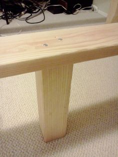 a wooden bench sitting on top of a carpeted floor