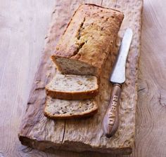 a loaf of bread sitting on top of a wooden cutting board next to a knife