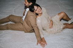 a man and woman are laying on the floor smiling at each other as they pose for a photo