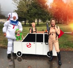 two people in costumes standing next to a car