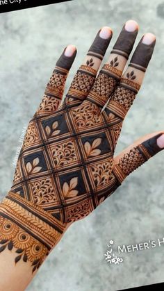 a woman's hand with henna tattoos on it