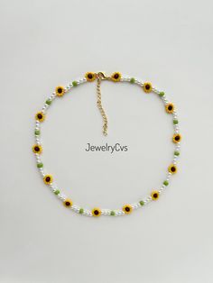 a yellow and white beaded bracelet with sunflowers on the front, and green beads