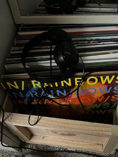 a record player and headphones sitting on top of a stack of records