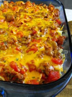 a casserole dish with meat, cheese and tomatoes