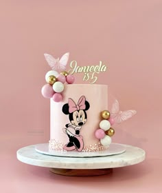 a minnie mouse birthday cake with pink and gold decorations