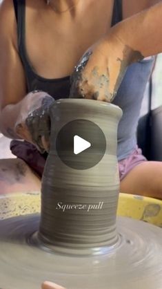 a woman is making a vase on a potter's wheel