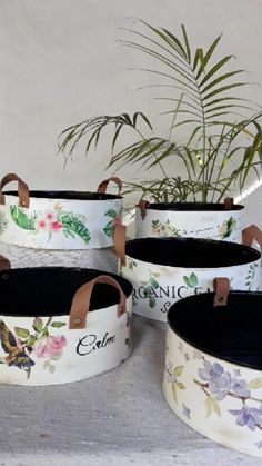 four white flowered pots with brown handles and leather handles, each containing a name