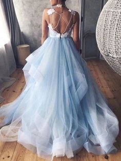 a woman standing in front of a mirror wearing a blue dress with sheer back and white lace