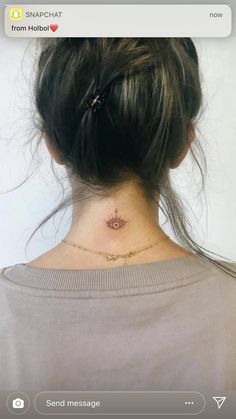 the back of a woman's neck with a small star tattoo on it