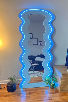 a mirror that is on the floor in front of a table with a potted plant