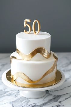 a white and gold cake with the number 50 on top