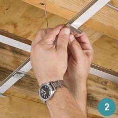 a man is working on the ceiling in his house with two screws attached to it