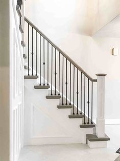 a white staircase with black railing and handrails