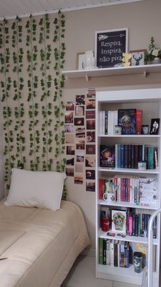 a bed sitting next to a book shelf filled with books