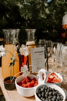 fruit and drinks are on the table for guests to enjoy at an outdoor wedding reception