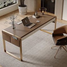 a desk with a laptop on it next to a chair and potted plant in front of a window