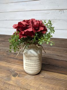 a vase filled with red flowers on top of a wooden table