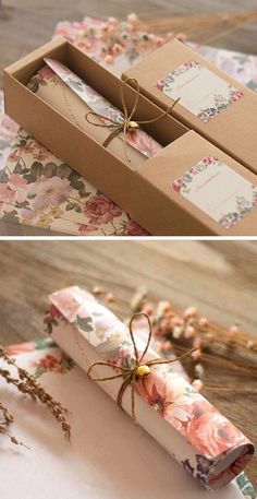 an open box with flowers on the inside and tied up in twine, sitting on top of a wooden table