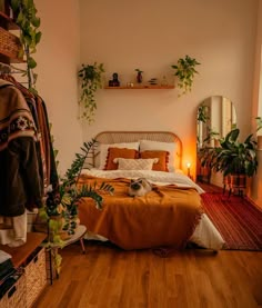 a bed sitting in a bedroom next to a mirror and potted plant on a shelf