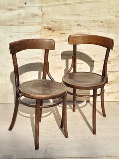 two wooden chairs sitting next to each other