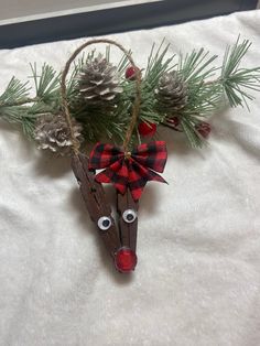 a wooden reindeer ornament with pine cones on it's head and eyes